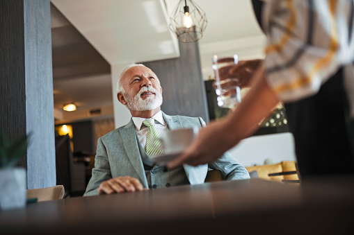 Senior businessman getting his coffee in cafe