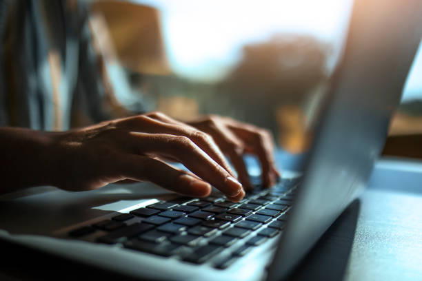 primer plano de las manos en el teclado de una computadora portátil - typing fotografías e imágenes de stock