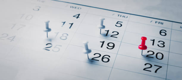 gestickte rote stifte auf einem kalender event planer kalender, uhr zum einstellen des zeitplans organisieren zeitplan, planung für geschäftstreffen oder reiseplanungskonzept. - caste system stock-fotos und bilder
