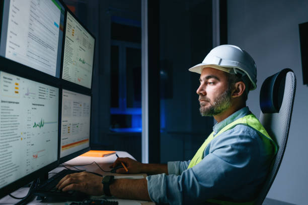 istock Bearded operator of factory control industry process using monitors. Engineer follow on production line 1422487023