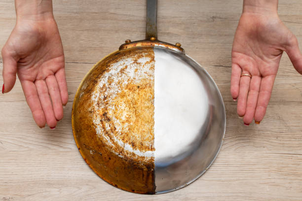 istock A woman's hand presenting a frying pan that is half burnt and half polished 1422488737