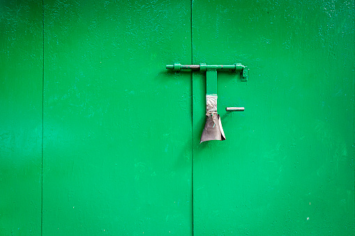 Old green grunge metal door with padlock