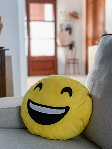 Cushion with smiley face emoticon on the sofa in the living room