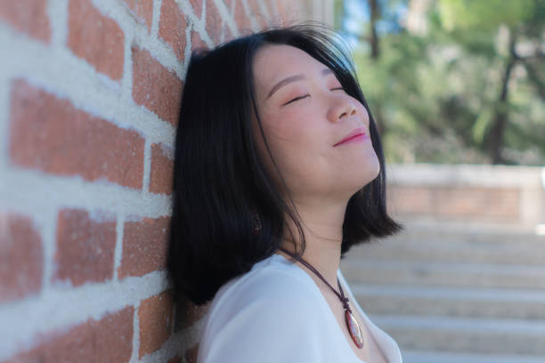 portrait de style de vie d’une jeune femme japonaise asiatique heureuse et belle souriant joyeusement à l’extérieur dans le parc de la ville - mid adult women human skin neat good condition photos et images de collection