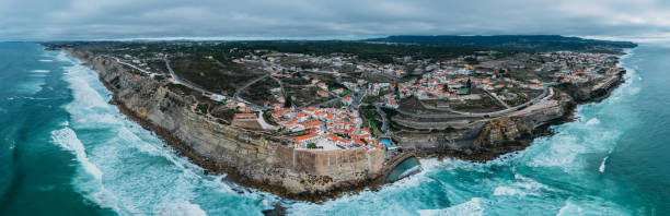Aerial panoramic drone view of Azenhas do Mar, a small Portuguese village situated on edge of steep cliff in a stunning location on coastline near Sintra Aerial panoramic drone view of Azenhas do Mar, a small Portuguese village situated on edge of steep cliff in a stunning location on coastline near Sintra azenhas do mar stock pictures, royalty-free photos & images