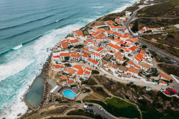 Aerial drone view of Azenhas do Mar, a small Portuguese village situated on edge of steep cliff in a stunning location on coastline near Sintra Aerial drone view of Azenhas do Mar, a small Portuguese village situated on edge of steep cliff in a stunning location on coastline near Sintra azenhas do mar stock pictures, royalty-free photos & images