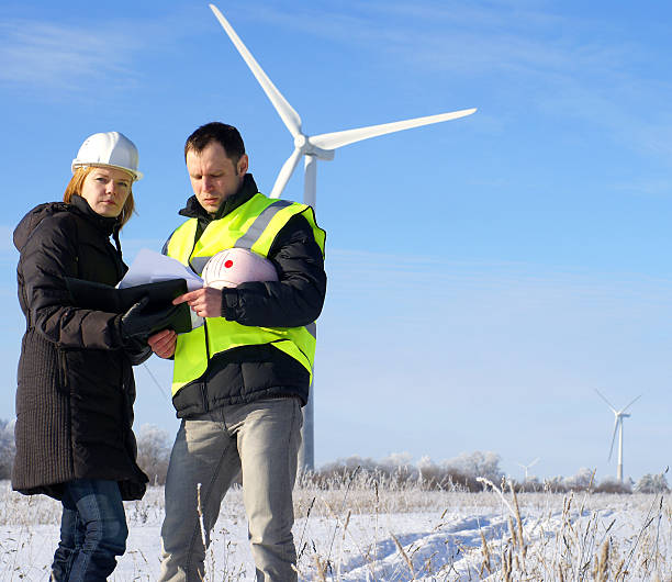 istock team of engineers against wind turbines on background 142250093