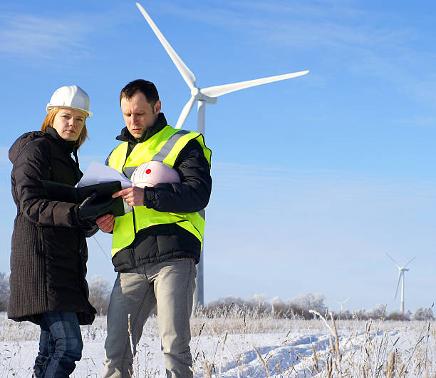 team of engineers against wind turbines on background stock photo