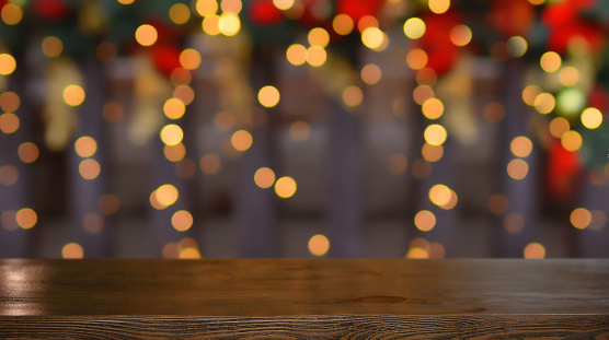 Christmas background. Empty wooden table on the background of the Christmas tree and New Year's bokeh.Ready for product montage