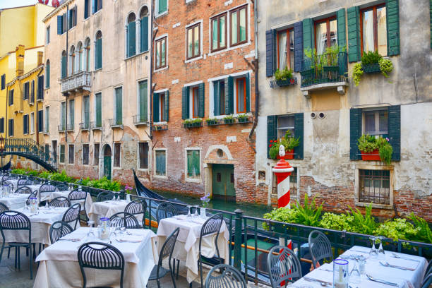 ltable of a restaurant with vinegar and olive oil at old town of Riva del Garda in Italy. The background is blurred.