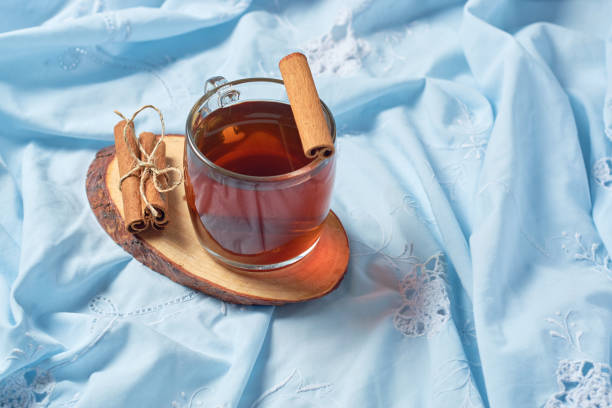 a cup of cinnamon tea and cinnamon sticks. overhead shot