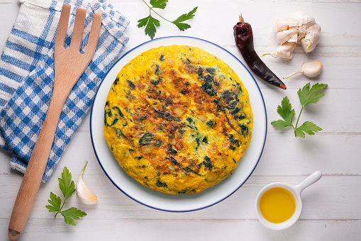 Spinach and potato omelette. Traditional Spanish tortilla recipe. Top view shot.