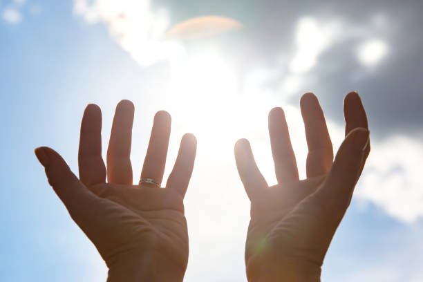 istock raised woman hand against the sunny sky 1422511280