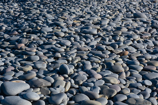 stacked black stones with reflections on blue clean background
