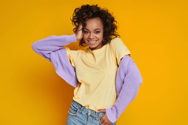 istock Attractive African woman smiling while standing against yellow background 1422513610