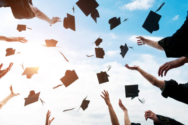 Graduating students hands throwing graduation caps in the air Graduating students hands throwing graduation caps in the air. graduation throwing cap stock pictures, royalty-free photos & images