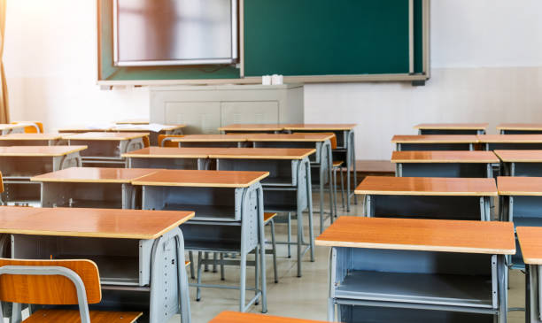 istock Empty modern classroom with chairs, desks and chalkboard 1422516129