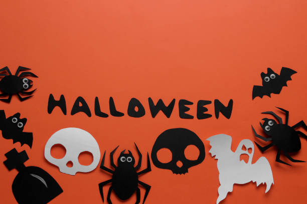 istock Halloween holiday. Composition with different halloween paper figures. view from above. on orange background 1422517919