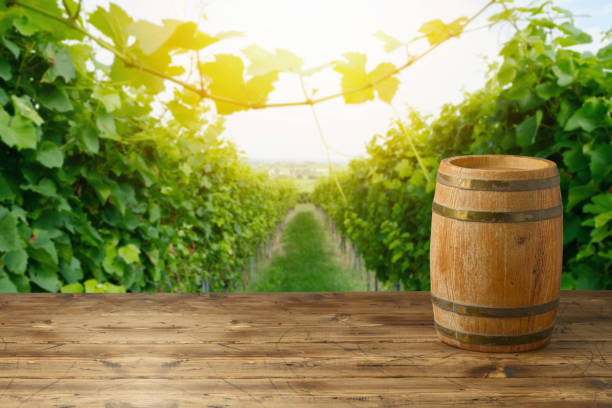 istock Empty wooden table with wine barrel over beautiful vineyard background. Mock up for design and product display 1422518354