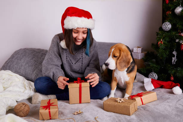 istock A girl in a Santa Claus hat opens a gift box. 1422518493