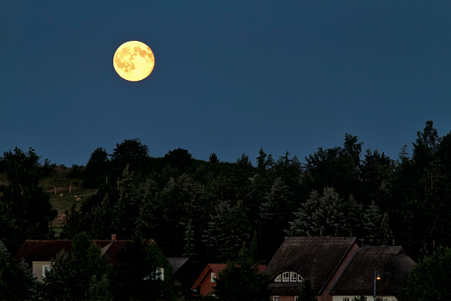 Full moon in the night sky over Alt Reddevitz/Mönchgut, island of Ruegen
