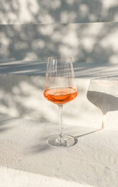 rosé-weinglas auf hellen betonstufen mit sommerschatten - foodstyling stock-fotos und bilder