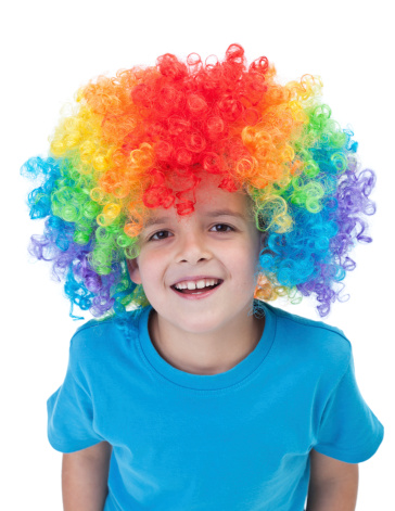 Happy clown boy with large colorful wig - isolated
