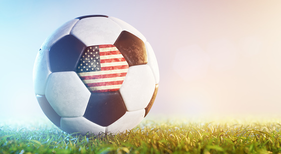 Football soccer ball with flag of USA on grass. American national team