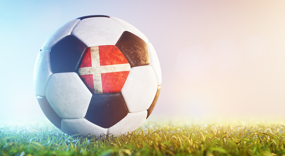 Football soccer ball with flag of Denmark on grass. Danish national team