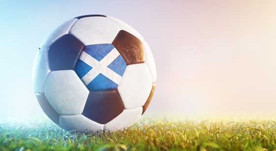 Football soccer ball with flag of Scotland on grass. Scottish national team