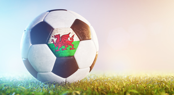 Football soccer ball with flag of Wales on grass. Welsh national team