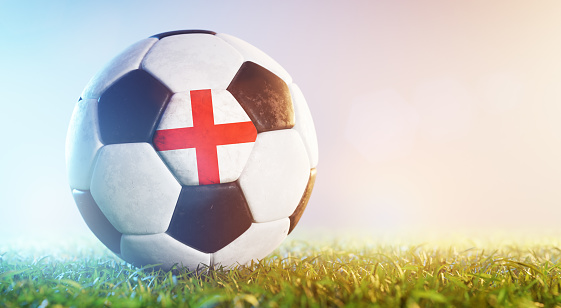 Football soccer ball with flag of England on grass. English national team