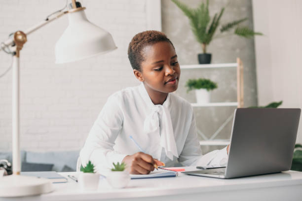 istock Black woman student studying foreign language at home, looking webinar on laptop. Remote work concept. Usage of modern technologies. Chatting with friend 1422531640