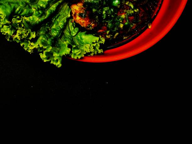 Indonesian traditional dish which is a plate of grilled chicken and lettuce on the black surface