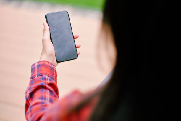 istock View over shoulder woman holding smart phone. 1422534221