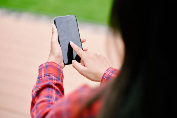istock View over shoulder woman holding smart phone. 1422534222