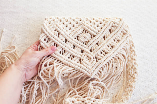 istock Handmade macrame pattern close up. Macrame braiding and cotton threads on wooden table.  Female hobby.  ECO friendly modern knitting DIY natural decoration concep. Copy space 1422540080