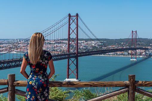 Woman discovering Lisbon and the Tagus River during a sunny day of summer.