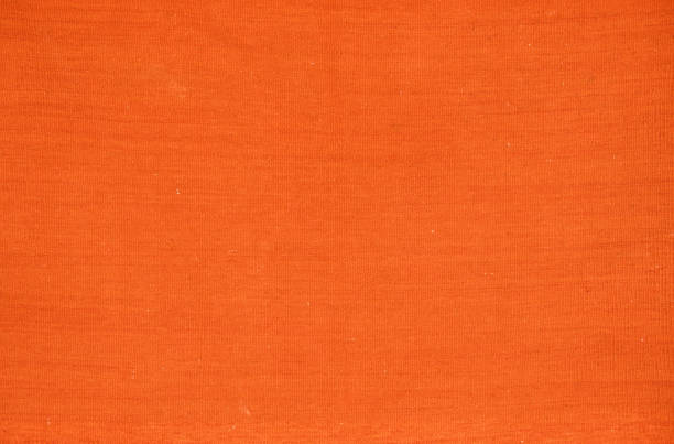 An old orange woven carpet in a solid color. An old orange woven carpet in a solid color. raffia stock pictures, royalty-free photos & images