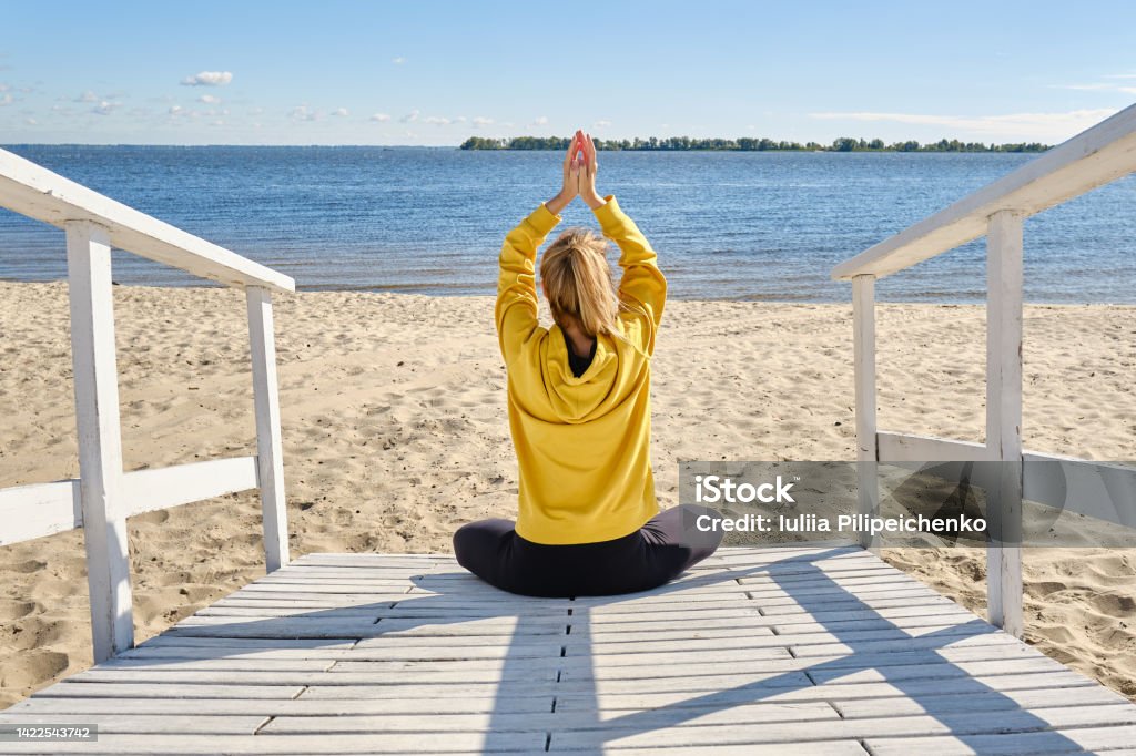 Women In Sportswear Sitting In A Lotus Position And Meditating During Yoga  Classes On The Seashore Practicing Yoga Lesson Breathing Meditation Doing  Ardha Padmasana Exercises Wellness Concept Stock Photo - Download Image