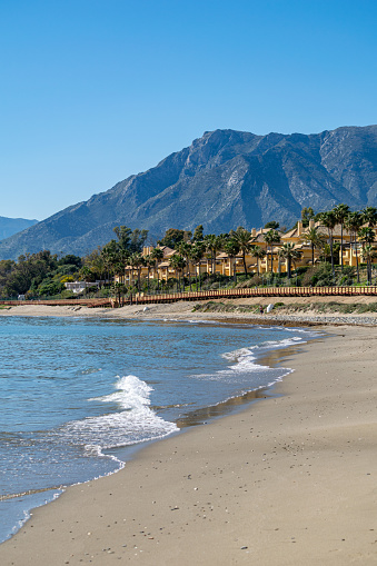 A beachfront portrait view of the mountains and coastlines of Marbella in southern Spain during the summer