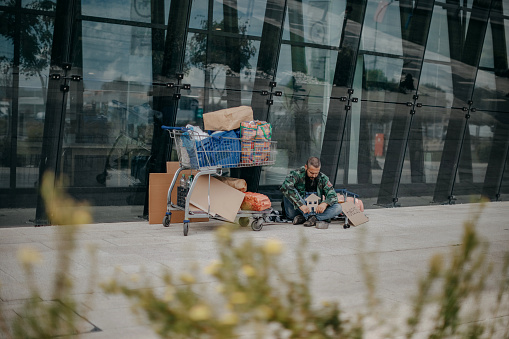 Homeless man asking for help on sidewalk