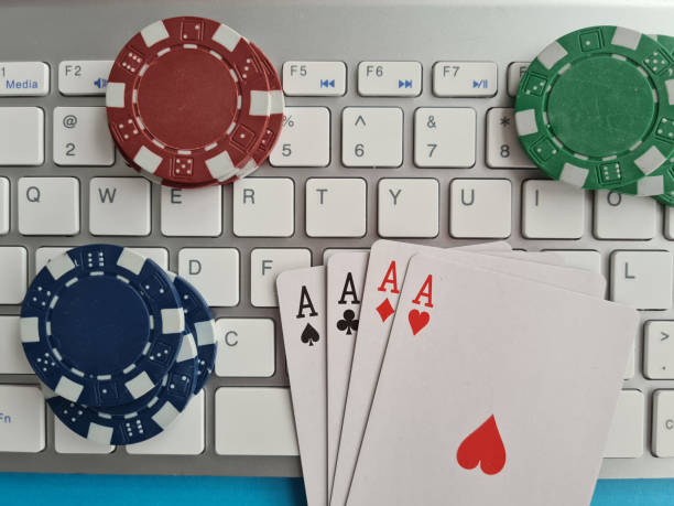 istock Computer keyboard four aces and cards casino chips and dice closeup 1422546974
