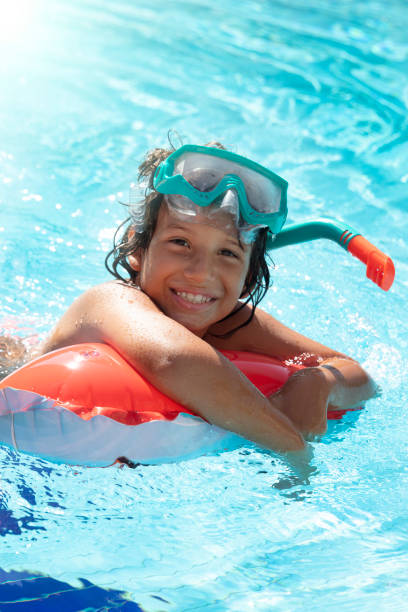 istock Happy Young Boy Fun in the Swimming Pool 1422550832