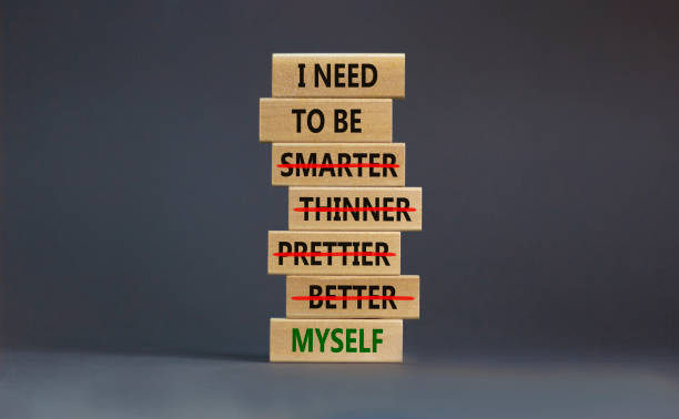 Be myself symbol. Businessman hand. Wooden blocks with words 'i need to be myself, not smarter, thinner, prettier, better'. Beautiful grey background, copy space. Psychological, be myself concept. stock photo