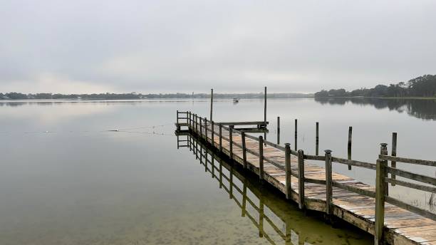 istock Dock on calm water in the morning. 1422557517