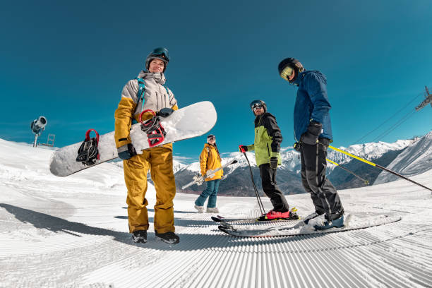 Group of skiers and snowboarders at ski resort Group of tourists skiers and snowboarders stands at ski resort. Winter sports concept snowboard stock pictures, royalty-free photos & images