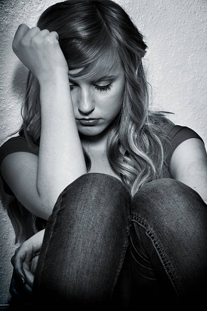 istock Girl with sad expression sitting down with hand on head 142256043