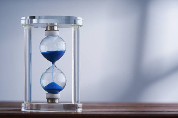 istock hourglass against gray backgroundwith window light 1422563860