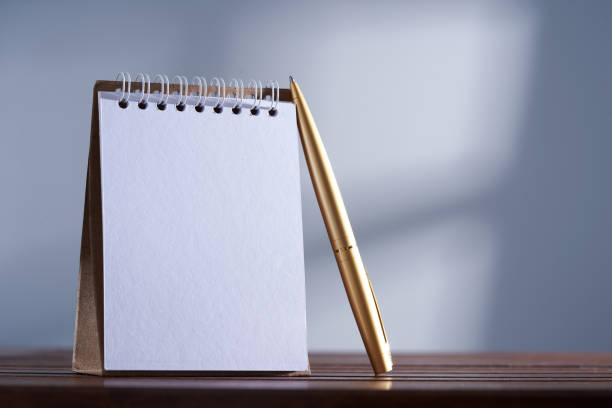 istock triangle note pad and gold pen against gray background 1422563863